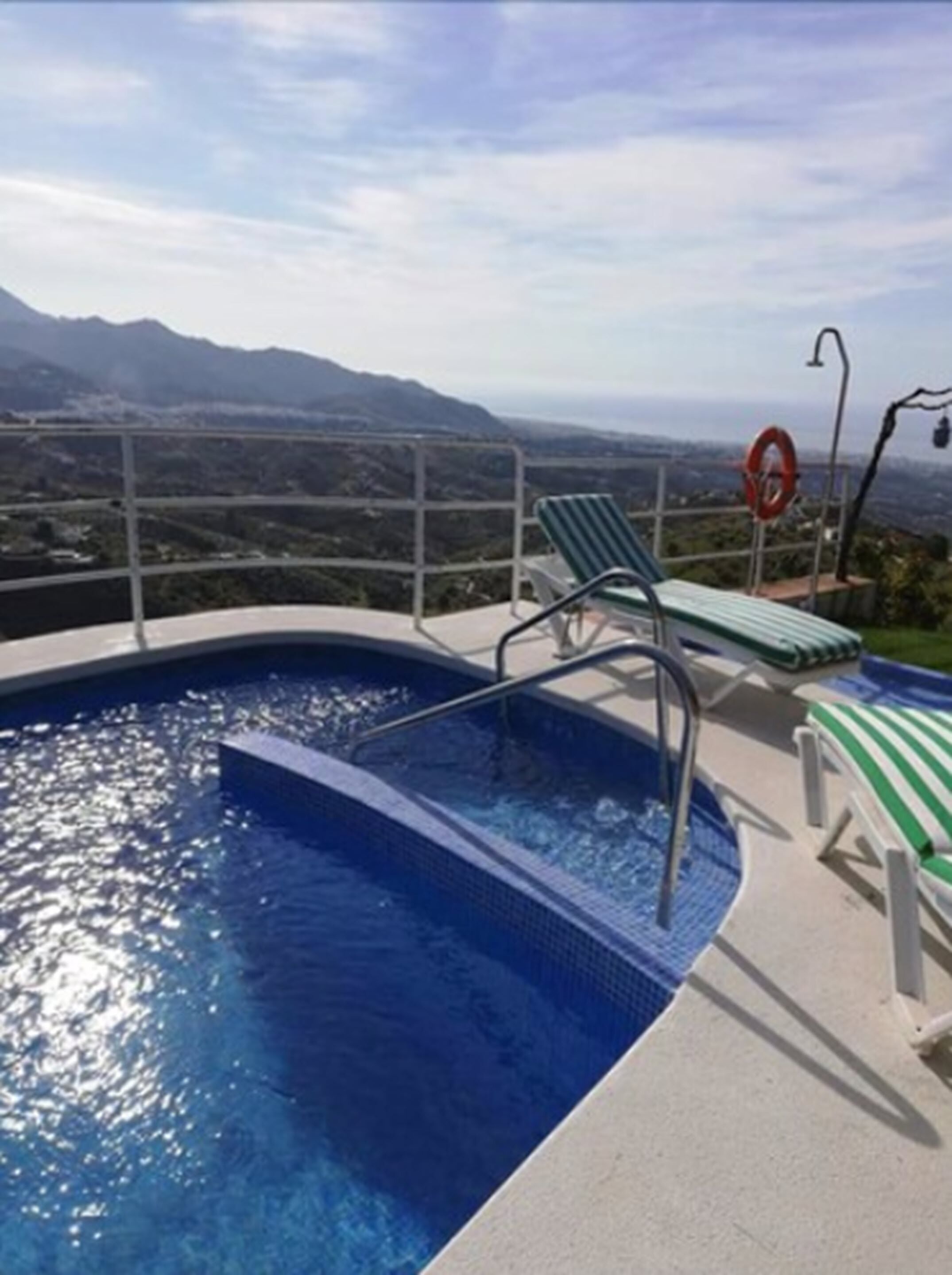 Una piscina con vistas a montañas al fondo.