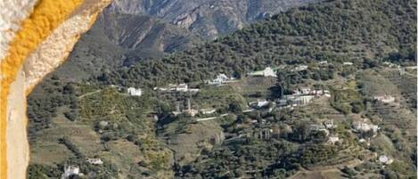 A mountainous landscape with scattered buildings, likely a rural or semi-rural area.