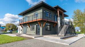 A modern two-story house with a balcony, a staircase, and a garage.