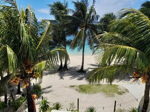 A beach with palm trees and a clear view of the ocean. - Marnin's Place Boracay (Boracay Island)