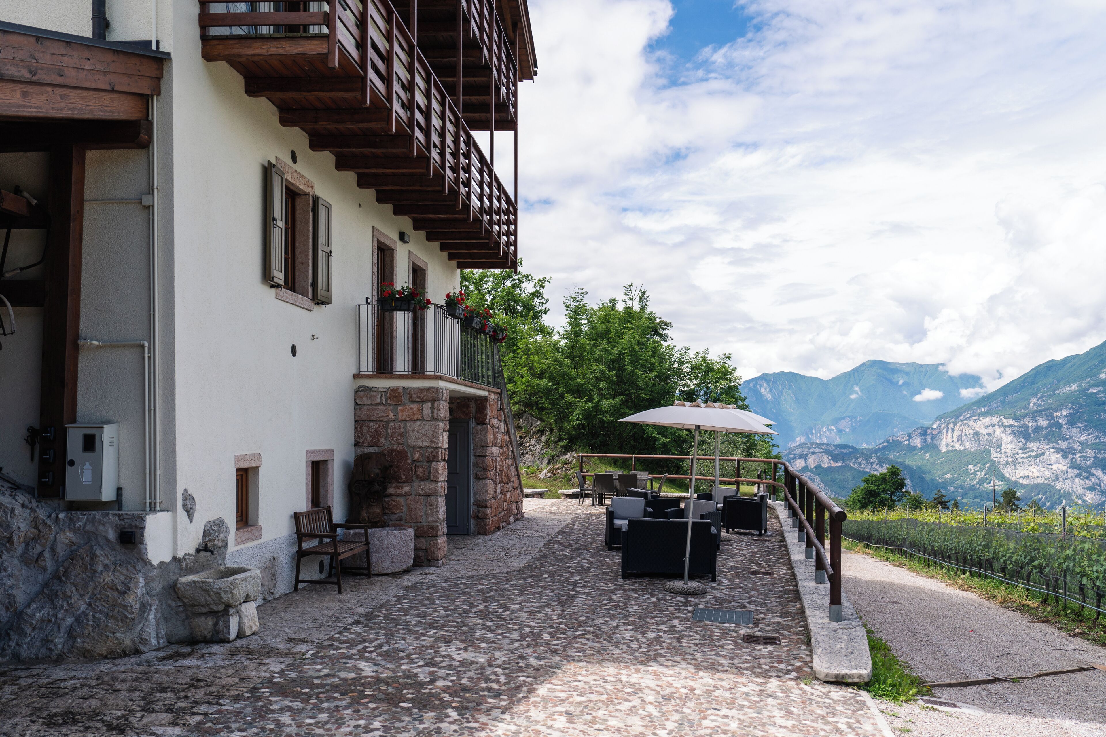 A stone building with outdoor seating and a view of mountains.