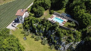 An aerial view of a property with a swimming pool, a large building, and surrounding greenery. - Maso Salim (Drena)