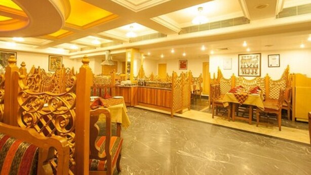 Un amplio vestíbulo de hotel con muebles de madera ornamentados y una zona de bar central.
