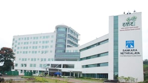 Un moderno centro médico con una entrada destacada y un cartel que indica Sankara Nethralaya.