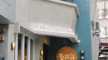 En bygning med et skilt, der siger "Travel Hostels", og et andet skilt med japanske tegn.