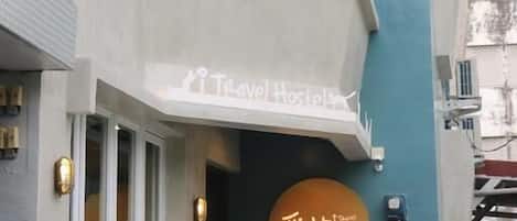 A building with a sign reading "Travel Hostels" and another sign with Japanese characters.