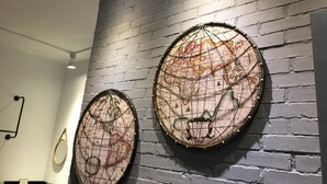 Two circular wall decorations with a map design, mounted on a brick wall. - itravel Hostel (Hualien City)