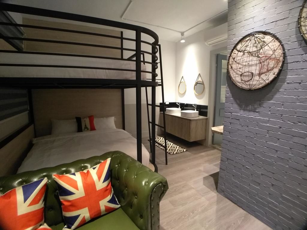 A bunk bed room with a green leather sofa and a map on the wall.