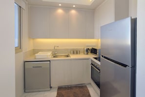 Departamento | Cocina privada | Refrigerador con congelador, microondas, horno y parrilla de estufa 