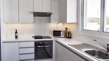 Appartement | Privékeuken | Een koelkast met diepvriezer, een microgolfoven, een oven, een kookplaat