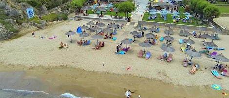 On the beach, sun-loungers, beach umbrellas, beach bar