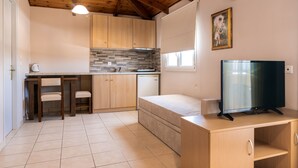 Une cuisine compacte avec des meubles en bois, une cuisinière encastrée et un petit réfrigérateur.