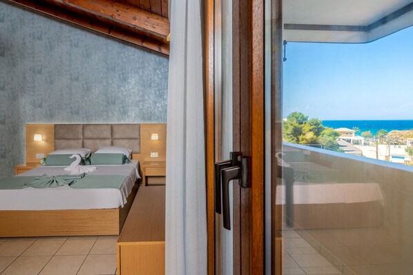 A bedroom with a bed, bedside tables, and a view of the sea. - Plaka Sungrace Studios & Apartments (Zakynthos)