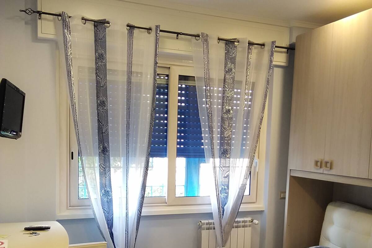 Un dormitorio con cama, escritorio y silla.