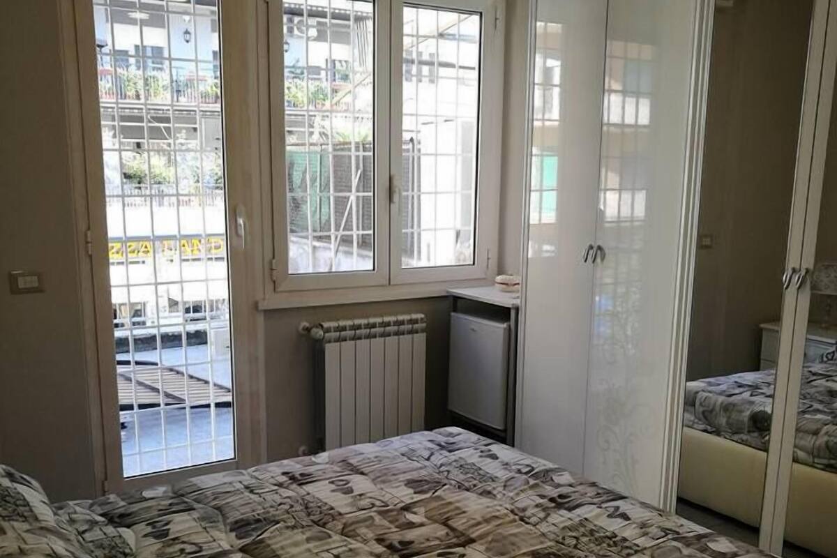 Un dormitorio con cama, armario y ventana con vistas al exterior.