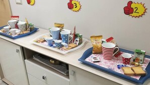 A breakfast setup with trays of food, cups, and plates on a counter. - B&B Fratelli Nicoli (Rome)