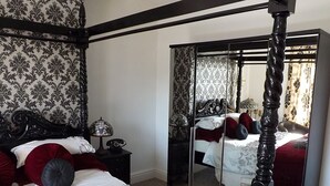 A bedroom with a four-poster bed, a large mirror, and a wardrobe. - Peniarth Arms Hotel (Tywyn)