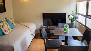 Une chambre d’hôtel avec un lit, un bureau, une télévision et une fenêtre donnant sur un paysage agréable.