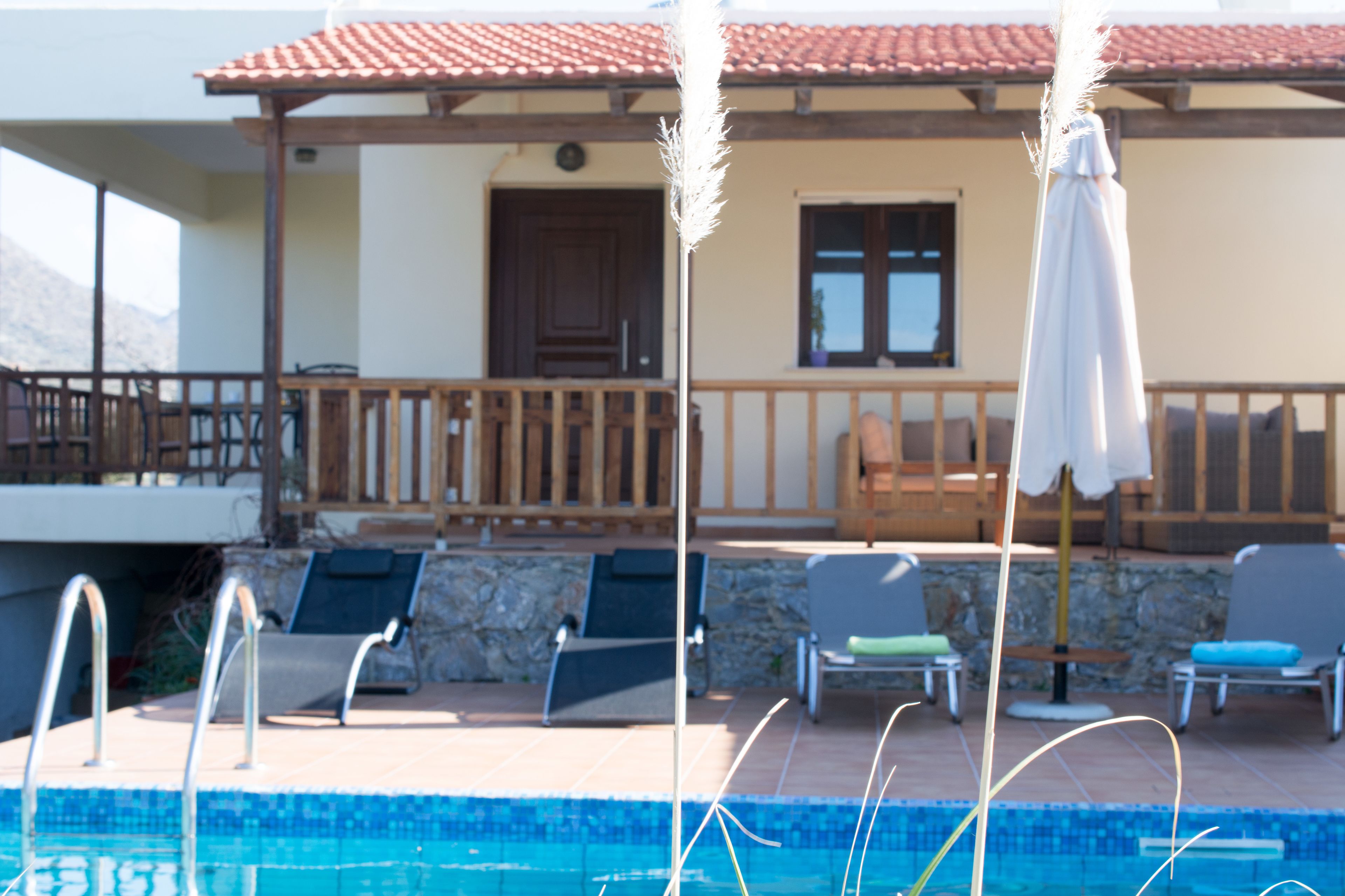A pool area with lounge chairs and a pergola.