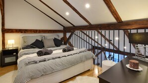 A bedroom with a bed, nightstands, a desk, and a view of the outdoors. - Libertas Apartment Zagreb (Zagreb)