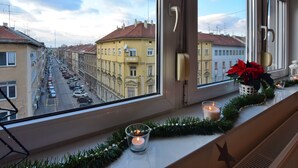A window view of a street with buildings, a candle, and a poinsettia on the windowsill. - Libertas Apartment Zagreb (Zagreb)