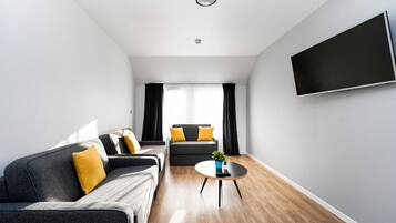 A modern living room with a grey sofa, a black armchair, and a coffee table.