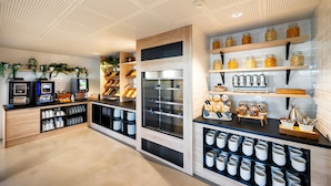 A modern kitchen with wooden cabinetry, stainless steel appliances, and shelves with jars and kitchenware. - Staycity Aparthotels, Near Disneyland® Paris (Bailly-Romainvilliers)