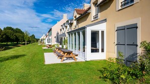 A row of houses with a well-maintained lawn and picnic tables. - Staycity Aparthotels, Near Disneyland® Paris (Bailly-Romainvilliers)