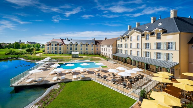 A hotel with a pool, outdoor seating, and a view of a river. - Staycity Aparthotels, Near Disneyland® Paris (Bailly-Romainvilliers)
