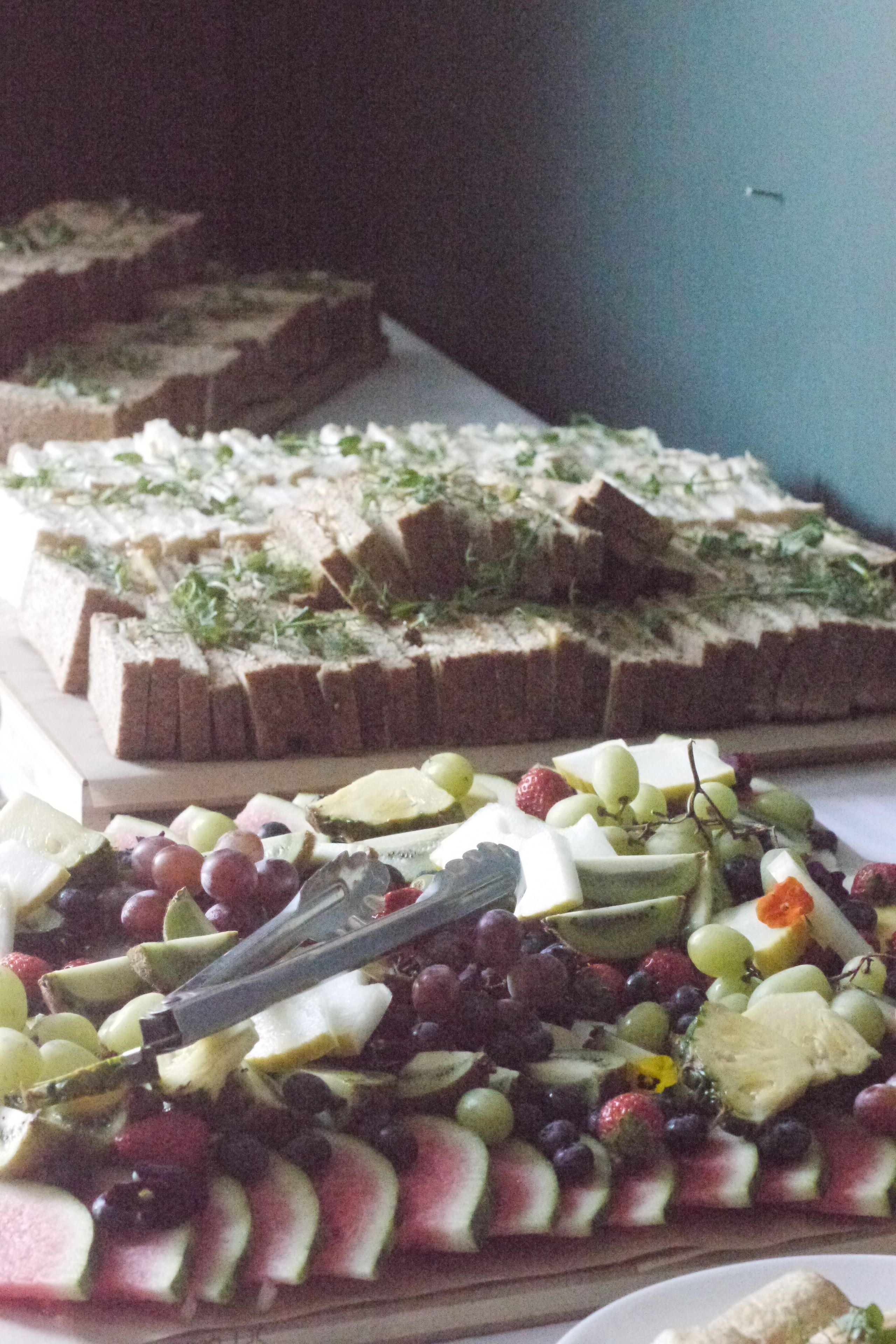 A variety of food items, including fruits and a cheese board, arranged on a table.