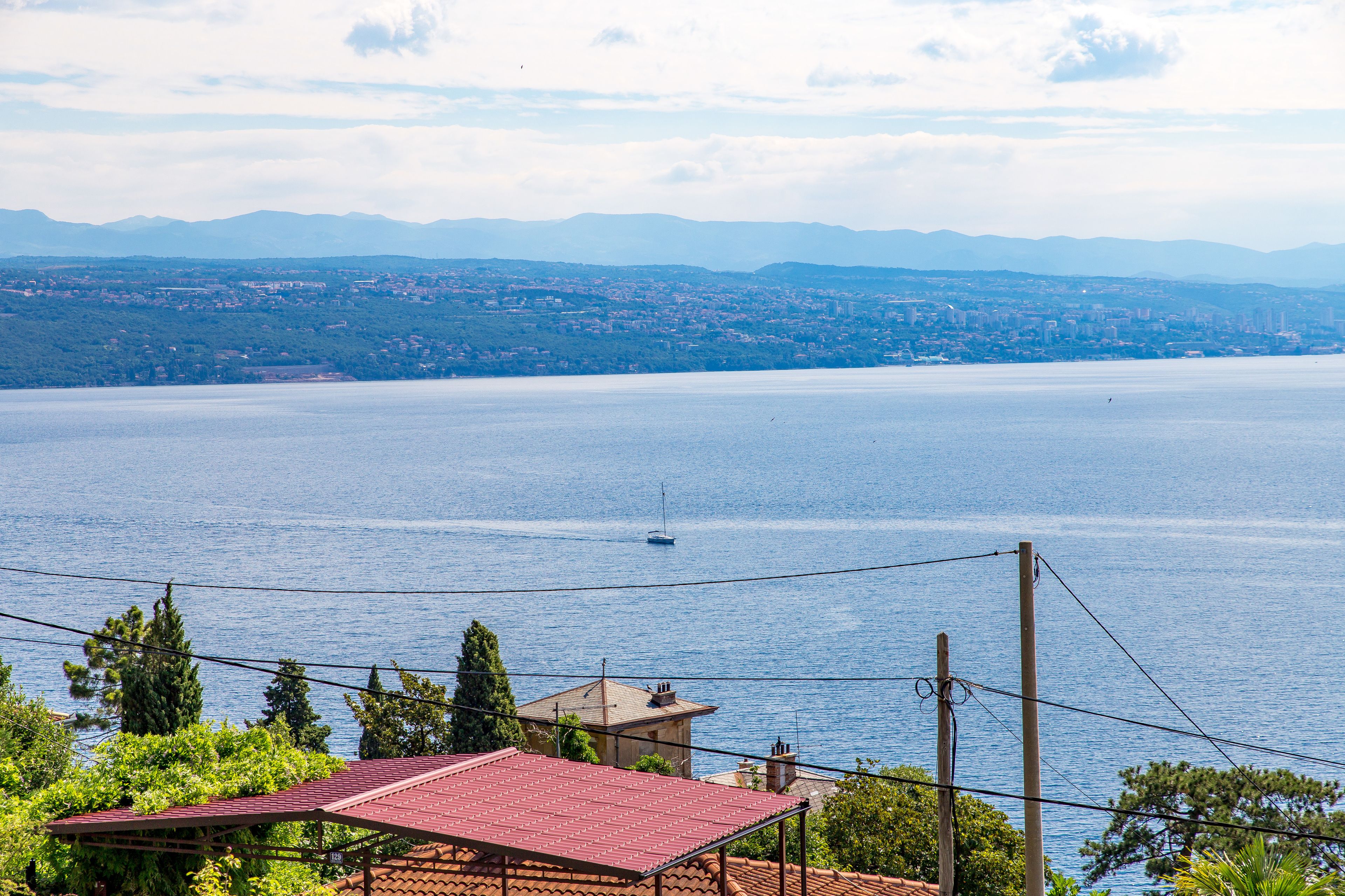 A coastal view with a clear sky, a body of water, and distant mountains.
