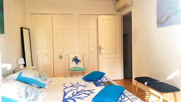 A bedroom with a bed, a chair, a desk, and a wardrobe.