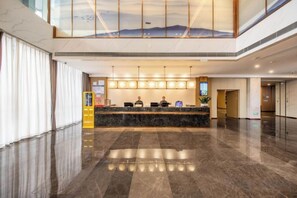 A spacious lobby with a reception desk, a large window, and a high ceiling. - Jintai Metropark Hotel (Taizhou)