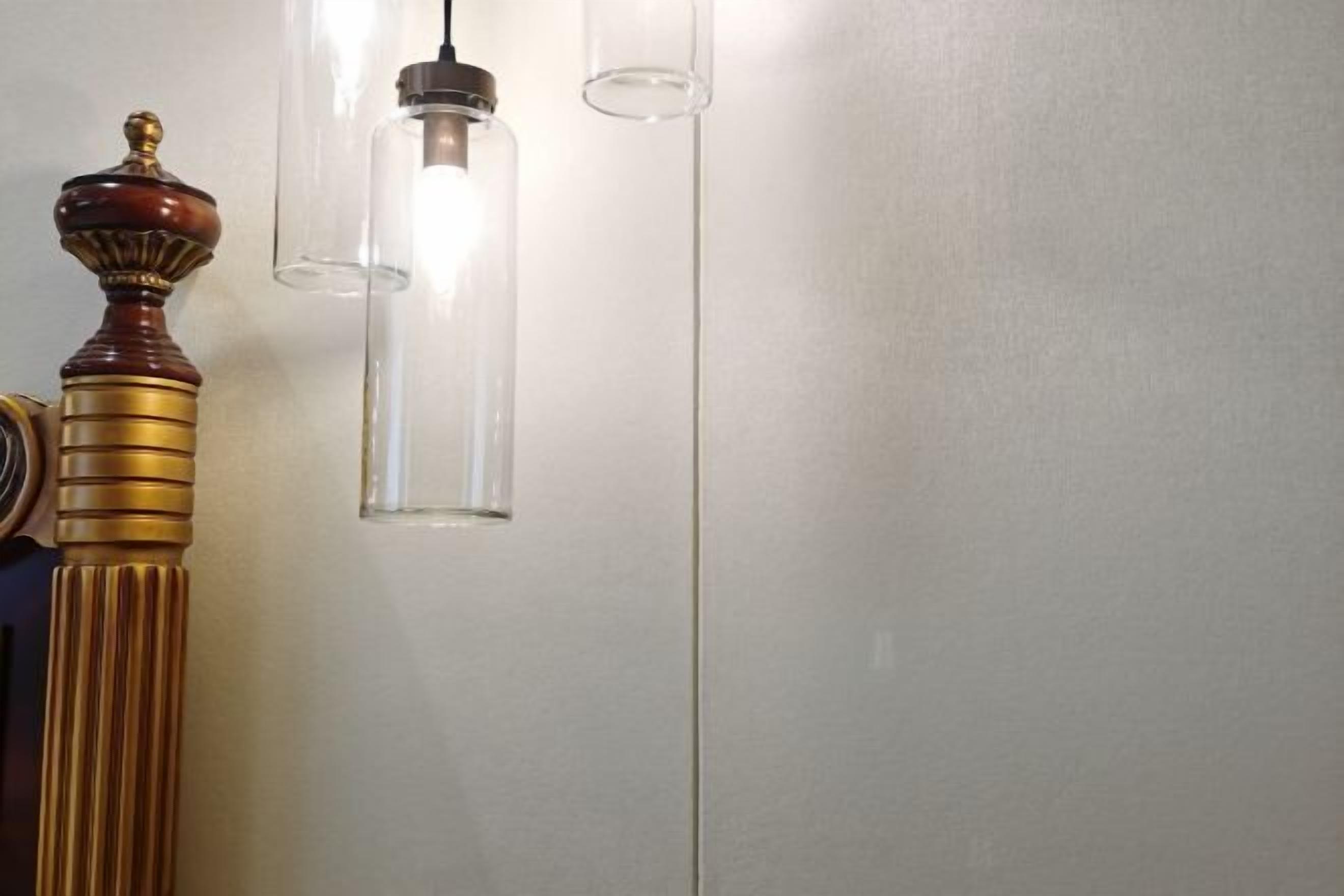 A wall with a decorative wooden column and a modern pendant light fixture.