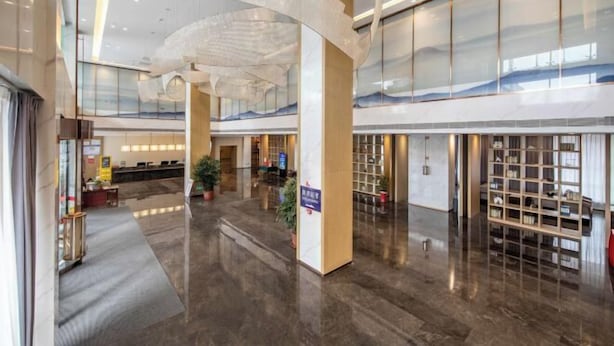 A spacious lobby with a reception desk, seating area, and a large glass wall. - Jintai Metropark Hotel (Taizhou)