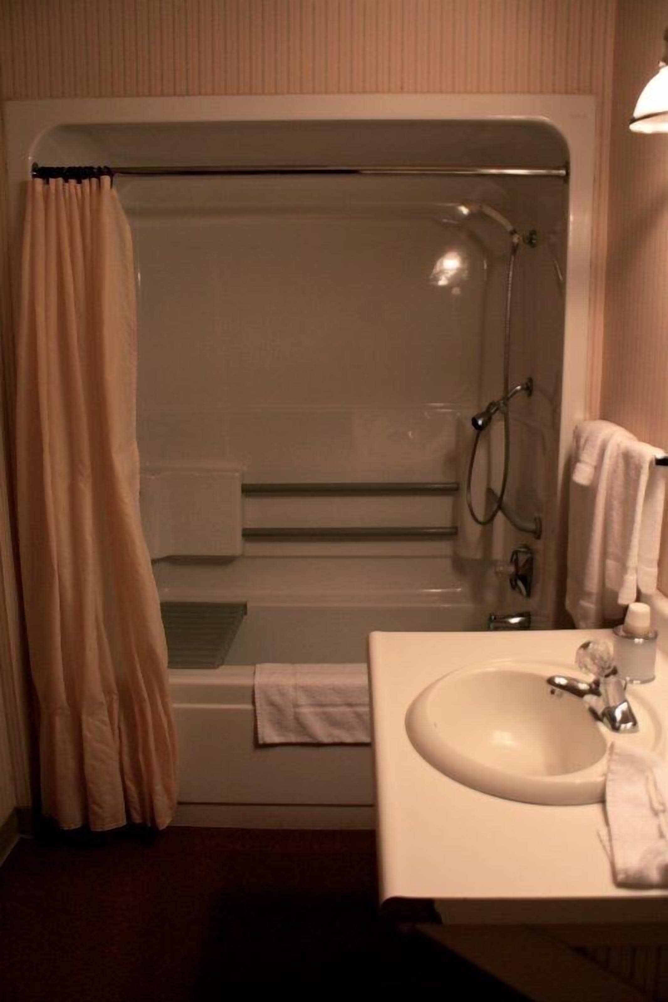 A bathroom with a bathtub, shower, and sink.
