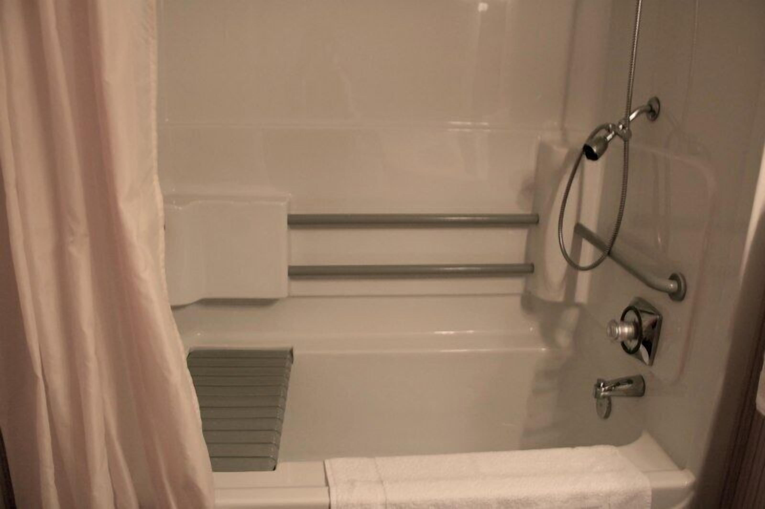 Un baño con bañera, ducha, toallero y retrete.