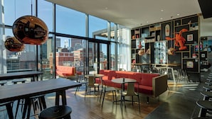 Un interior moderno con amplios ventanales, un sofá rojo y vistas a la ciudad.
