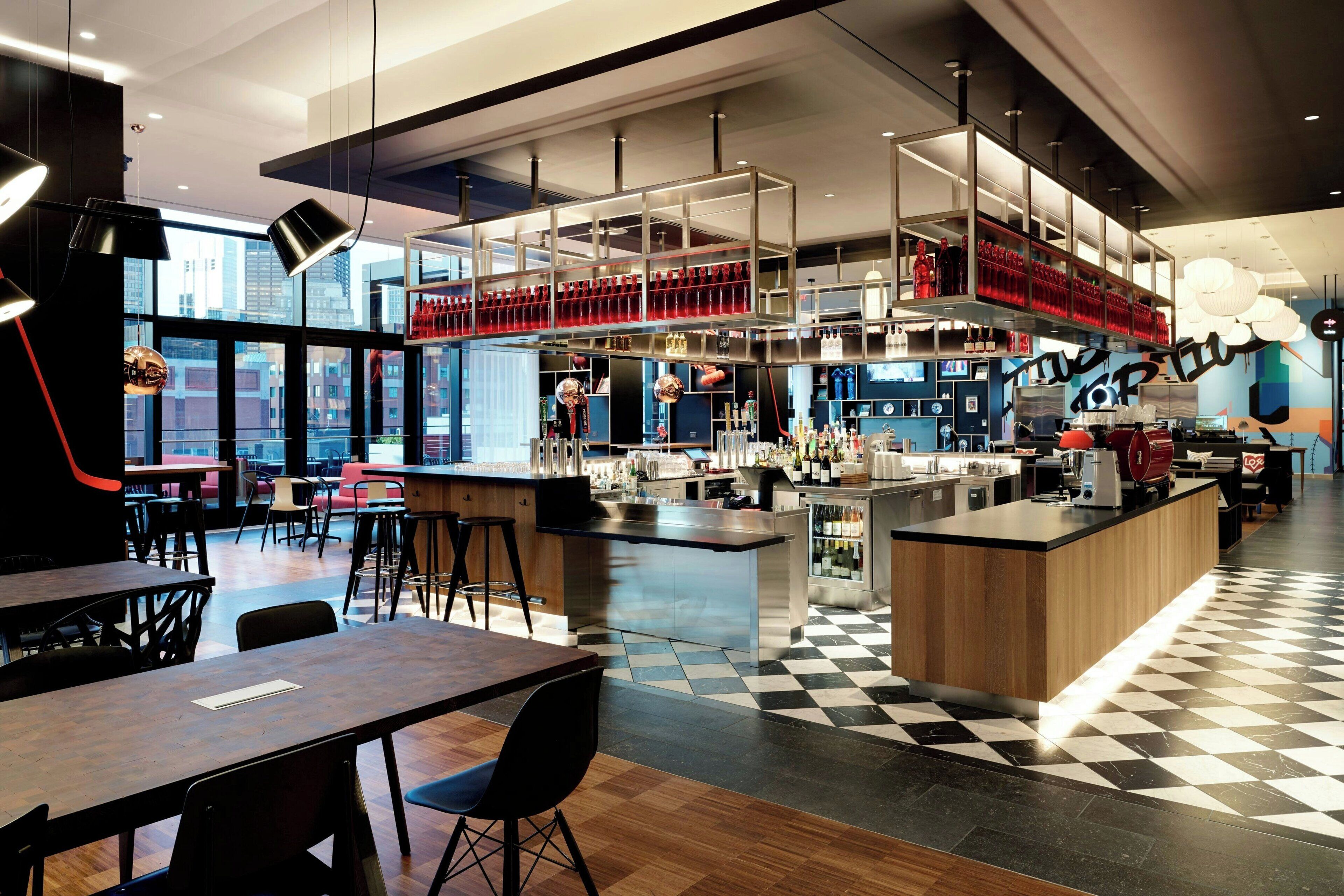 A modern bar area with a checkered floor, a central bar counter, and seating arrangements.