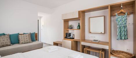 Un dormitorio moderno con una cama grande, un armario de madera, un espejo y un vestido colgado.