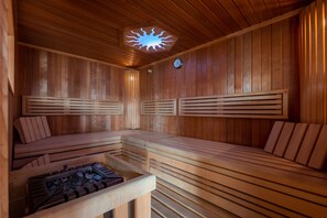 Een sauna met houten banken en een centraal verwarmingselement.