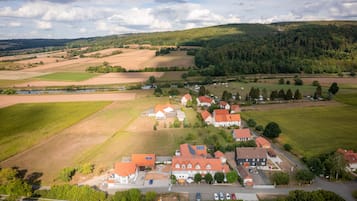 An aerial view of a rural village with houses, fields, and a river.