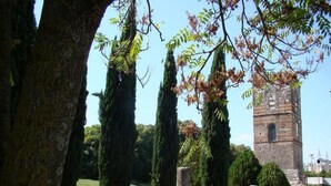 A cemetery with gravestones and a tower in the background.