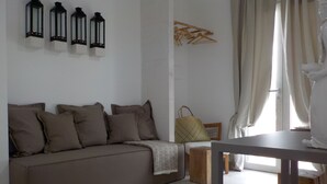 Una sala de estar moderna con un sofá, una mesita de madera y un ventanal con cortinas.