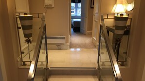 A staircase with glass railings and a light fixture on each side. - Beaufort House - Knightsbridge (London)