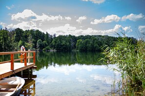 A wooden dock extending into a calm lake surrounded by dense forest. - Hotel Zum Rittmeister (Werder (Havel))