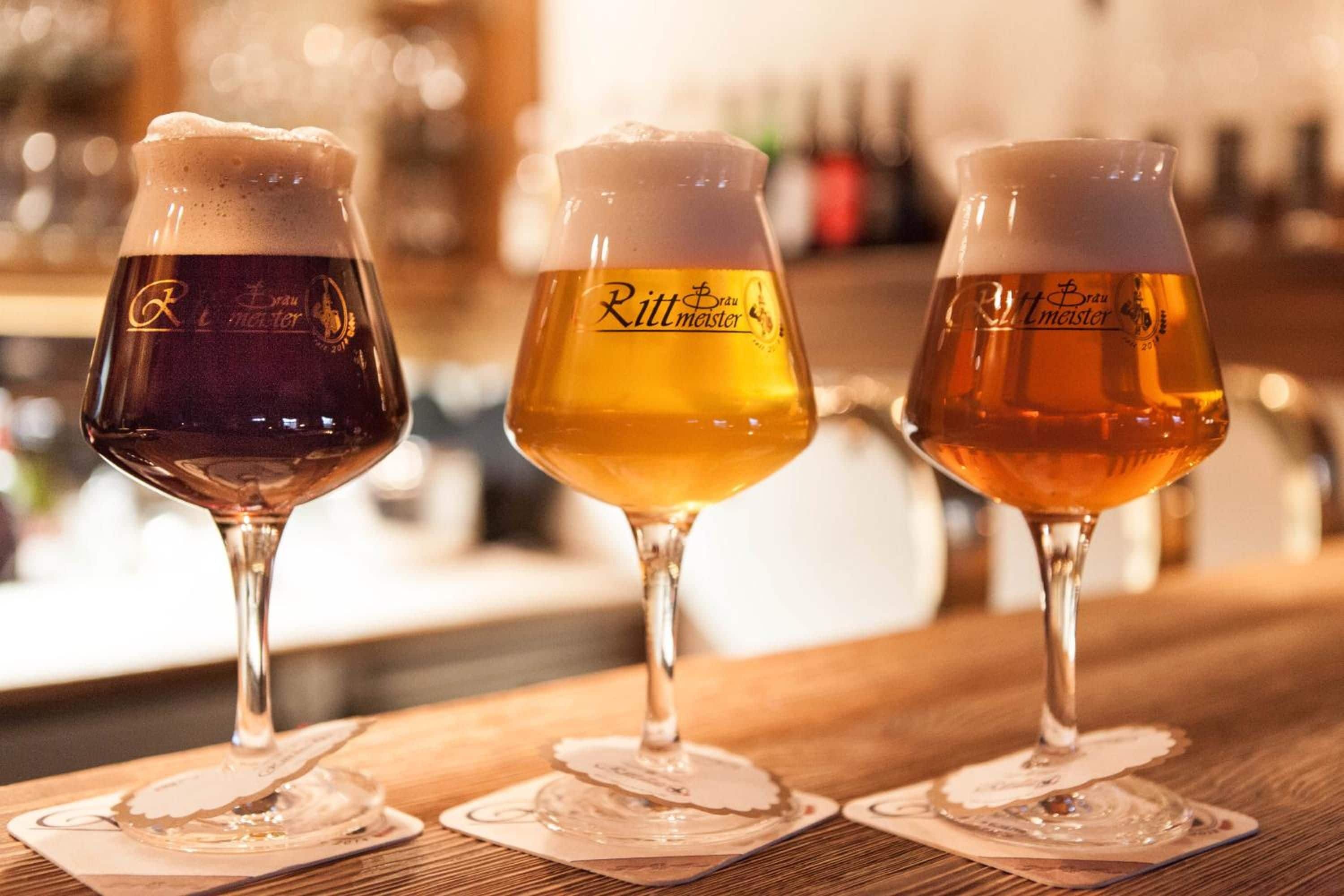 Drei Biergläser auf einer Bar.