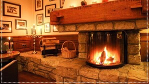 A cozy room with a stone fireplace, a wooden mantel, and framed pictures on the wall. - Hotel Zum Rittmeister (Werder (Havel))