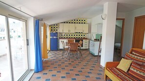 Un espacio habitable compacto con cocina, comedor y sofá.