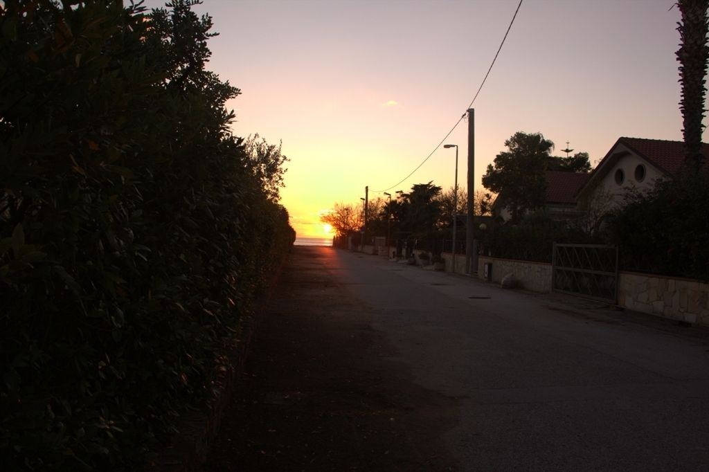 A quiet street at sunset with a building on the right.
